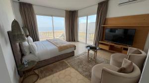 a hotel room with a bed and a flat screen tv at Villa La Falaise in Oualidia