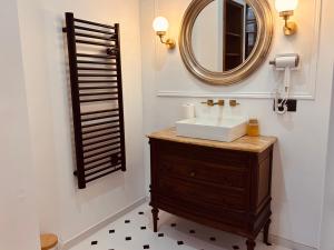 Un baño con un lavabo y un espejo en la pared. en La Suite, en Étretat 9 fotos más