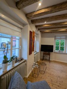 a living room with wooden ceilings and a flat screen tv at Das Kirch24 - DAS Ferienhaus in Heidenburg in Heidenburg +24 photos