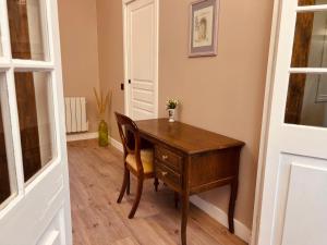 una mesa de madera con una silla y un escritorio en La Suite, en Étretat