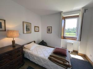 a bedroom with a bed with a dresser and a window at Casa do Paço in Paredes de Coura