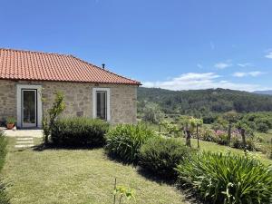 a stone house with a view of a garden at Casa do Paço in Paredes de Coura