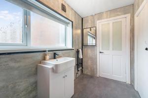 a bathroom with a white sink and a window at Modern High Spec House, Free Parking, 4 bed, sleeps 7 in Shield Row +34 photos