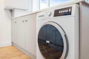 a white washing machine in a white laundry room at Modern High Spec House, Free Parking, 4 bed, sleeps 7 in Shield Row