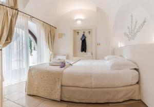 a white bedroom with a large bed in a room at Dimora Dell'Osanna in Carovigno