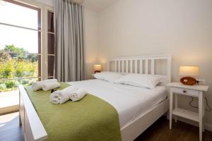 a bedroom with a white bed with towels on it at Villa Santa Lucia ZadarVillas in Turanj +33 photos