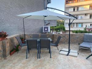a table with chairs and an umbrella on a patio at VN Home 1 in Pomorie