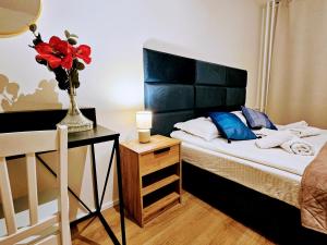 a bedroom with a bed with a vase of flowers on it at LIVE-INN PRAGUE APARTMENTS, Free Gym & Parking, Reception, Lifts, Roof Terrace & Game Room in Prague