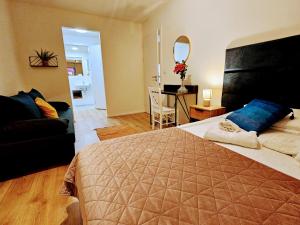 ein Schlafzimmer mit großem Bett und ein Wohnzimmer in der Unterkunft LIVE-INN PRAGUE APARTMENTS, Private Garden, Free Parking & Gym, Roof Terrace, Lounge & Game Room in Prag