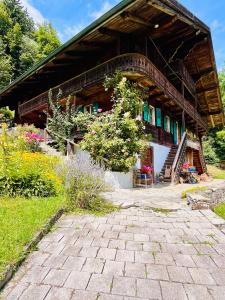 瓦尔·蒂利兹Aparthotel Mountain River Resort的一座大型木屋,前面设有庭院。