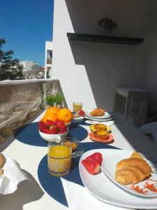 a table with plates of food and fruit on it at Holiday Spot in Portimão