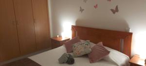 a bedroom with a bed with pillows and butterflies on the wall at Holiday Spot in Portimão