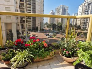 a balcony with potted plants and a view of a city at Great Rental near Poleg Beach in Netanya