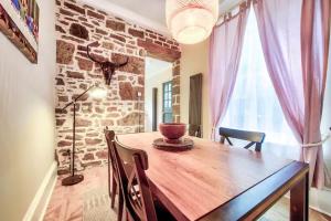 a dining room with a wooden table and a brick wall at West End Holiday Homes in Glasgow