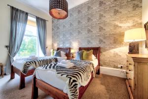 two beds in a bedroom with zebra print walls at West End Holiday Homes in Glasgow