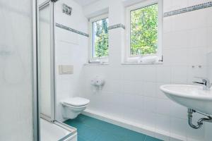 a white bathroom with a sink and a toilet at Haus Strandperle in Zinnowitz +18 photos