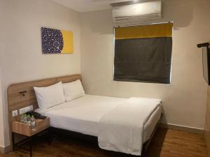 a bedroom with a white bed and a window at Hotel I-stay Hitec in Hyderabad