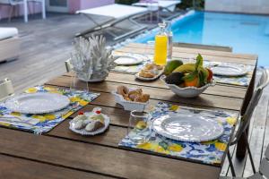 a table with plates of food on it next to a pool at Villa Olimpia in Mondello