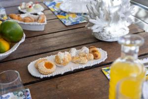 a table with plates of pastries and a bottle of orange juice at Villa Olimpia in Mondello