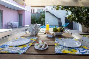 a wooden table with plates and food on it at Villa Olimpia in Mondello