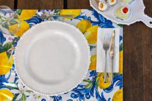 a white plate on a table with a table cloth at Villa Olimpia in Mondello