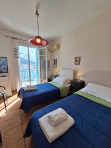 a bedroom with two beds and a large window at Blue Dolphin in Batsi