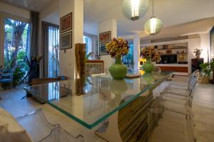 a living room with a glass table with vases on it at Villa Olimpia in Mondello