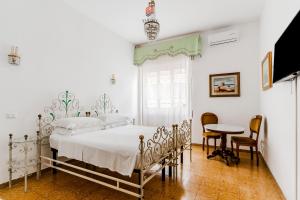 a bedroom with a bed and a table and chairs at Palazzo Grassi by Vivimy in Gallipoli