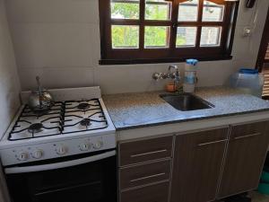 a kitchen with a stove and a sink at Las Carolas in Santa María +8 photos