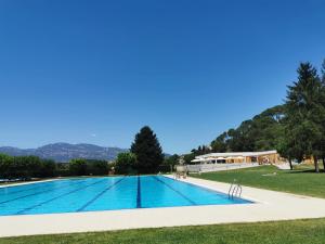 a swimming pool in a park with trees and mountains in the background at Ca l'Herminia in Gironella