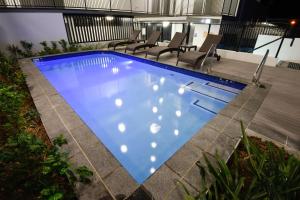 a large swimming pool with chairs around it at Pacific Sands Apartments Mackay in Mackay