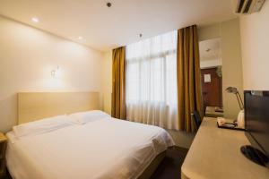 سرير أو أسرّة في غرفة في Motel Shanghai Pudong Lianyang New International Expo Centre