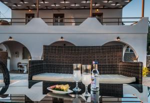 a table with wine glasses and a bowl of fruit on a patio at Oceanis Rooms in Adamantas