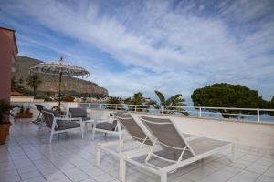 a patio with chairs and an umbrella on a balcony at Villa Olimpia in Mondello