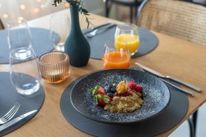 a plate of food with fruit on a table at Domus Hotel in Birštonas