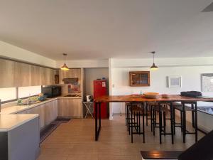 eine Küche mit einem Holztisch und einem roten Kühlschrank in der Unterkunft Oceana Suites Remanso de Algarrobo in San Antonio