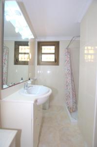 a white bathroom with a sink and a mirror at Apartamento con increibles vistas al mar in Can Picafort