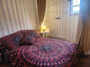 a bedroom with a bed with an umbrella on it at La Maison Conteneur in Amos