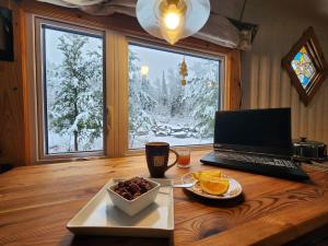 a table with a laptop and a plate of food at La Maison Conteneur in Amos