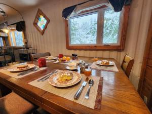 a wooden table with plates of food on it at La Maison Conteneur in Amos