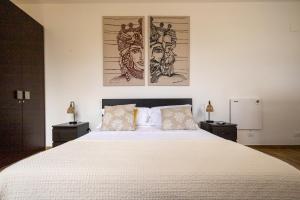 a bedroom with a large white bed with two night stands at Villa Olimpia in Mondello