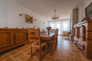 una sala da pranzo con tavolo e sedie in legno di Willa Tonkiele - Dom z Jacuzzi i Sauną na wyłączność a Tonkiele