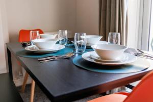 ダーリントンにあるDarlington 4BD Home: Modern Comfort & Free Parkingの黒いテーブル(皿、鉢、メガネ付)