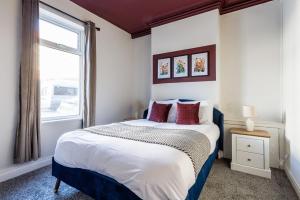 ダーリントンにあるDarlington 4BD Home: Modern Comfort & Free Parkingの大きなベッドと窓のある寝室