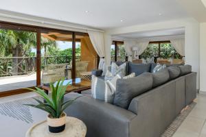 a living room with a large gray couch at San Lameer Villa - 14014 - 5 Bedroom Luxury - 10 pax - San Lameer Rental Agency in Southbroom