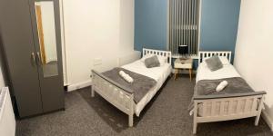 two twin beds in a room with a mirror at Modern Spacious 2 Bedroom Apt in Rowley Regis