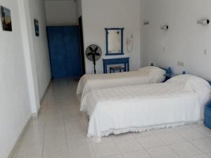 a room with two beds and a mirror on the wall at Dawn's Rooms in Patitiri