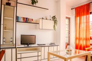 a living room with a tv and a table at Vivienda Vacacional Mar y Arena Puerto de Tazacorte in Tazacorte