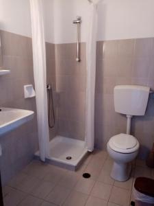 a bathroom with a shower and a toilet and a sink at Dawn's Rooms in Patitiri