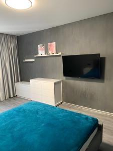 a bedroom with a large bed and a tv at Апартаменти Бела Виста in Varna City